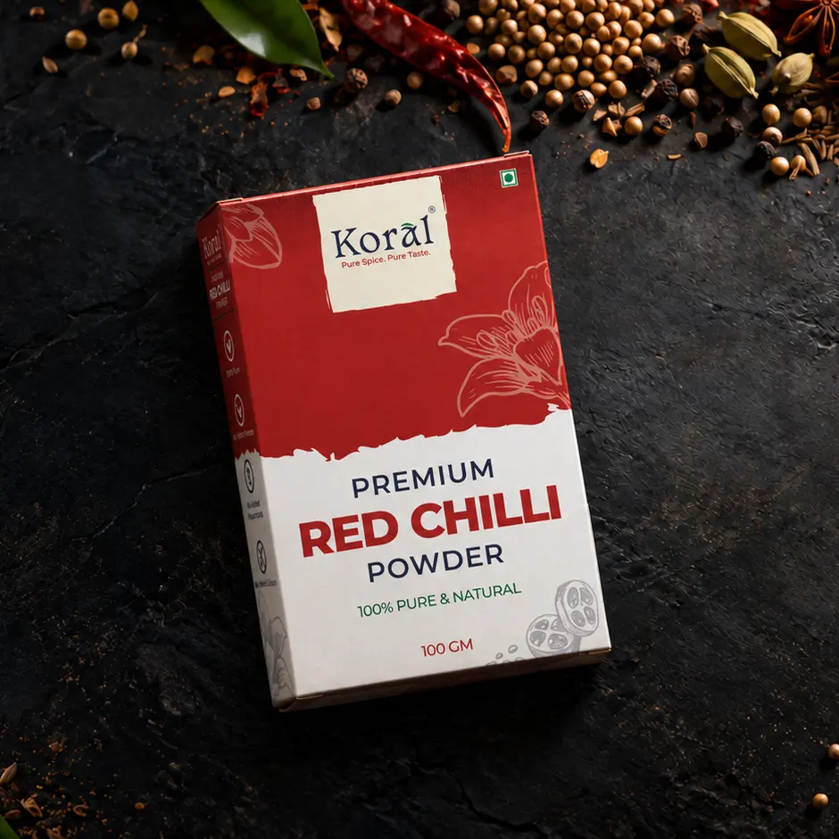 The Red Chilli Powder box lying on dark slate among whole spices